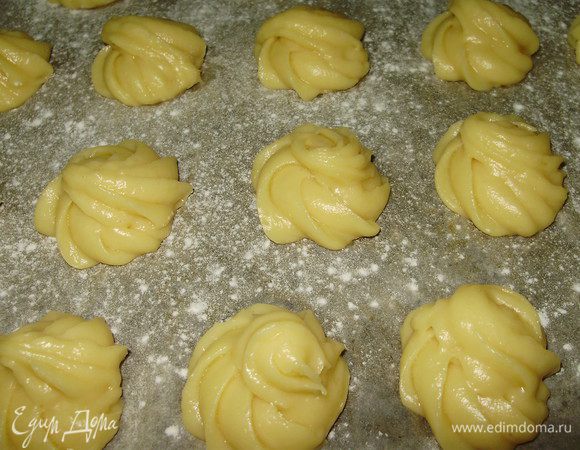 В кастрюлю налить воду, посолить и добавить масло поставить на огонь. Когда закипит добавить муку постоянно помешивая и снять с огня вымешать до однородной массы и по одному вводить яйца перемешивая. Когда замесили однородное тесто поместить его в кондитерский мешок и сформировать профитроли на выстланном пергаментом протине.