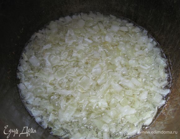 Казан поставить на сильный огонь, влить масло, положить лук, обжарить его до золотистости.
