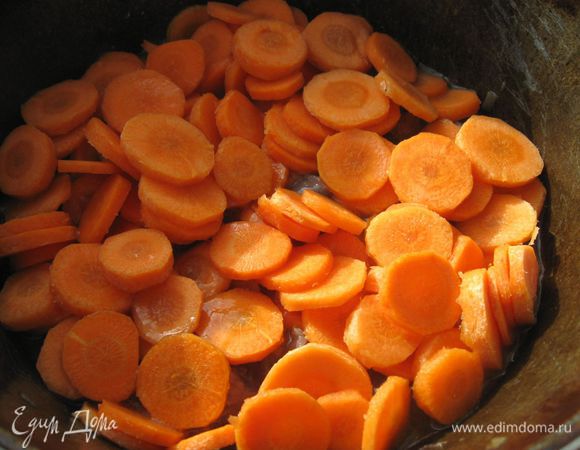 Через 40 минут, когда мясо будет почти готово, перемешать его в последний раз.  Больше ничего не перемешивать. Добавить морковь, разровнять.  

