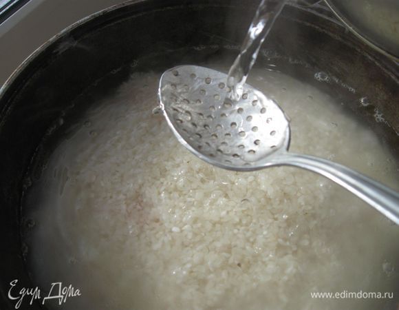 Залить через шумовку, чтобы не  разрушить слои,  кипяток  на 1,5-2 см выше риса. Огонь  не уменьшать.