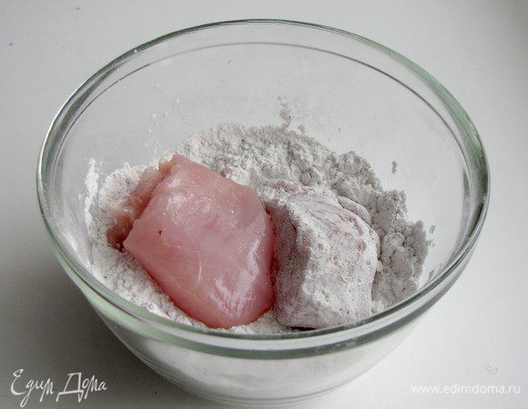 Куринное филе нарежьте крупными кусками. В небольшой миске смешайте крахмал и черный перец. Обваляйте каждый кусочек в крахмале.