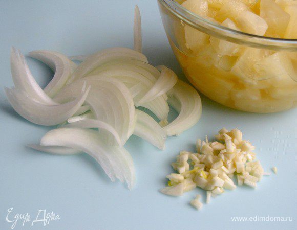 Пока курица жарится, крупно нарежьте лук, измельчите чеснок. Откройте ананасы.