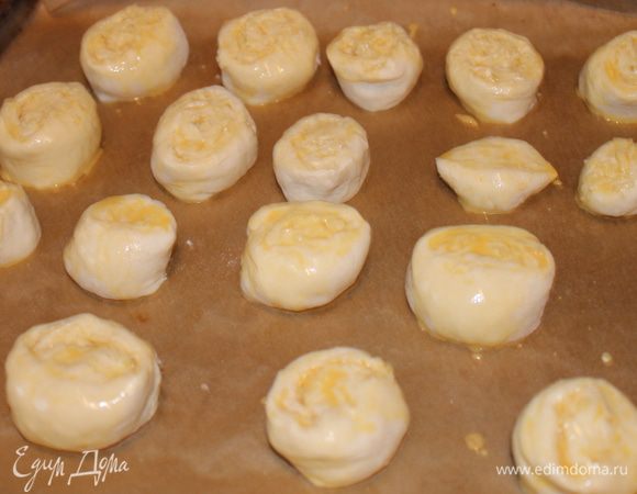 скручиваем в рулет , и режем на сигменты примерно 3 см шириной , кладем на лист..смазываем желтком . 
