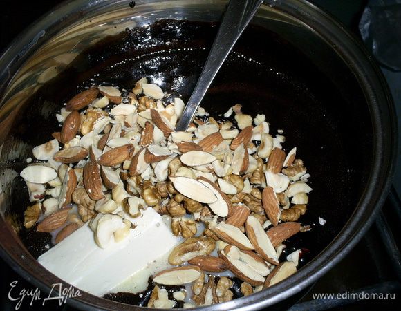 Снимаем кастрюльку с огня и добавляем грубо порубленные орехи и масло. Перемешиваем до однородности.