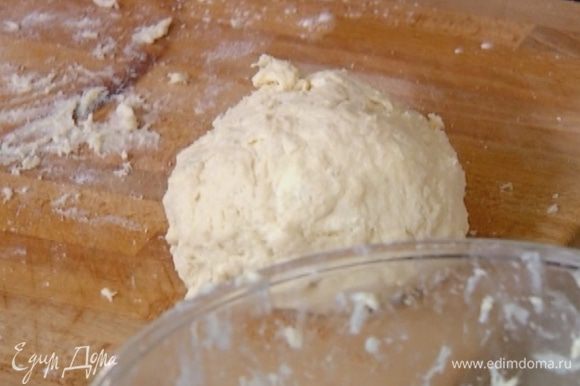 Сделать в центре муки с маслом углубление, всыпать разрыхлитель, щепотку соли, влить молоко и быстро вымесить тесто, затем сформировать из него шар.
