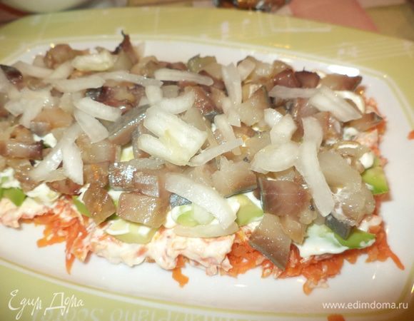 Селедку разделайте и нарежьте кубиками. Лук нарежьте произвольно, промойте и сбрызните лимонным соком. Уложите селедку поверх авокадо, посыпьте луком и смажьте майонезом.