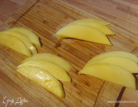 Манго очистить, разрезать вдоль ядра на 2 части, каждую половинку разрезать вдоль ещё на 2 части. Итак у нас получились 4 кусочка, от каждого  из которых отрезаем по 3 тонких пластинки одинакогого размера и откладываем их в сторону. Они нам понадобятся для сервировки блюда.