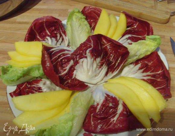 Выкласть большую  тарелку листъями салата, по цвету салат должен быть контрастным,  пластинки манго расположить по тарелке с четырёх сторон. По желанию можно приправить салат светлым бальзамико и оливковым маслом.