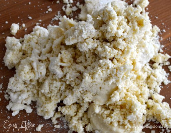 Добавляем белое сухое вино. Еще раз включаем миксер. Выкладываем на стол тесто и формируем из него шар. Заворачиваем в пищевую пленку и убираем в холодильник минимум на 30 мин.   