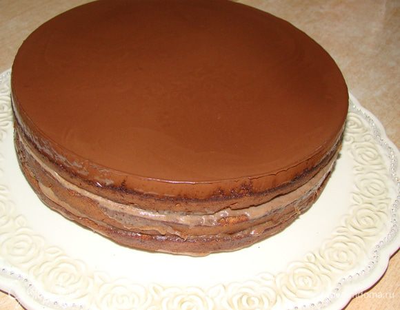 Закрепить тортовое кольцо (от разъемной формы, в которой вы выпекали торт) вокруг коржей, залить глазурью верх. Когда застынет - снять кольцо и обмазать бока