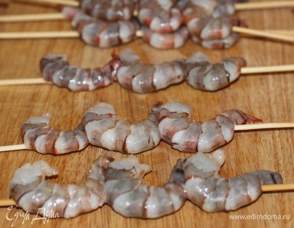 Достать креветки из маринада и нанизать на шпажки по 3 штуки.