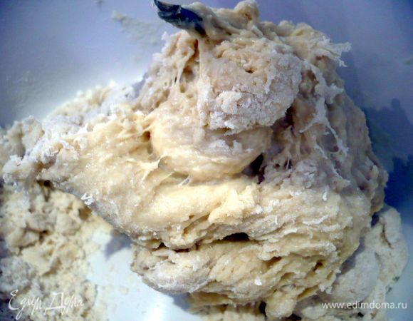 В другую половину муки добавим разрыхлитель и перемешаем. Вольем другую часть муки, смешанной с яйцами и молоком. Масло растопим, подождем, пока оно остынет и смешаем со сметаной. Хорошо перемешаем два вида мучной смеси между собой до однородности и только потом добавим смесь масла и сметаны. Перемешаем хорошо. У нас получается очень эластичное и податливое тесто. Накроем его полотенцем и займемся начинкой.