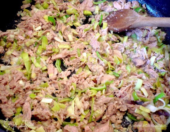 Лук-порей нарежем  полукольцами. Чеснок натрем на мелкой терке. Растопим на сковороде 1 ст.л. сливочного масла и обжарим в ней слегка лук с чесноком. Добавим тунец вместе с маслом. Пообжариваем еще в течение двух минут. Рис откинем на сито и промоем холодной водой, дадим воде стечь и выложим рис к тунцу и луку. Перемешаем, посолим и поперчим. Бруснику смешаем с сахаром и добавим 1 ст.л. воды, доведем до кипения. Снимем с огня и сольем образовавшийся сок. 