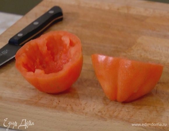 Помидор разрезать поперек пополам, ложкой вынуть сердцевину.