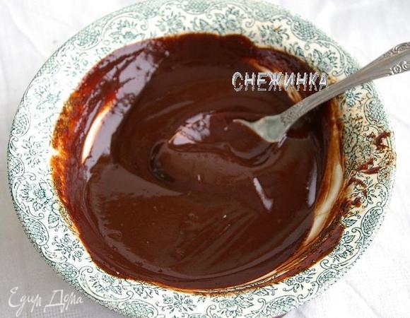 Для глазури растапливаем на водяной бане шоколад с маслом и сахарной пудрой. Когда масса стала однородной, снимаем с водяной бани и, помешивая массу, вливаем горячие сливки. Размешиваем до однородности и остужаем.