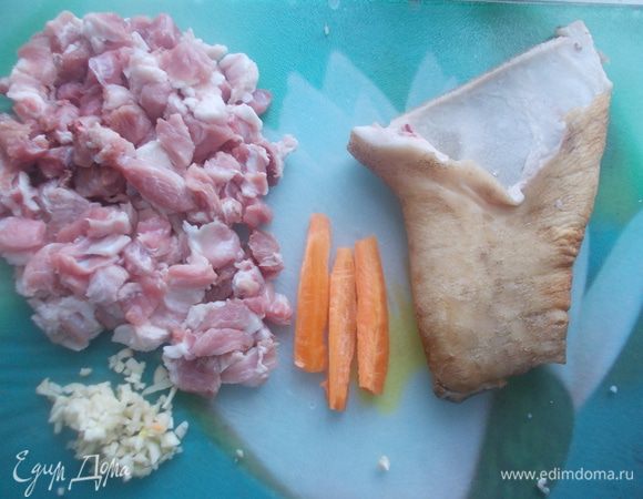 Затем с кости срезать мясо и мелко его порезать, посолить, поперчить. Из моркови вырезать три полосочки. Чеснок мелко измельчить.