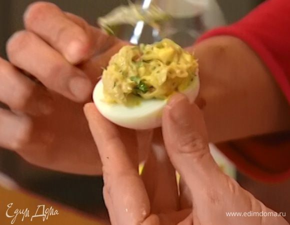 Яичные белки заполнить начинкой и выложить на помидоры.