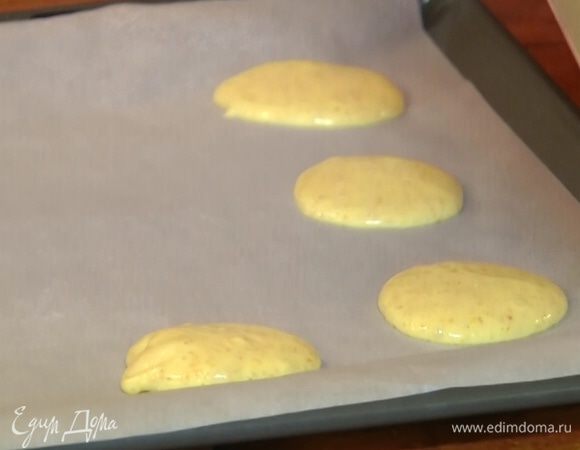 Противень выстелить бумагой для выпечки и ложкой выложить тесто в форме лепешек.