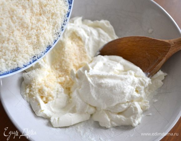 Возьмем рикотту, разомнем ее ложкой и добавим к ней 80 г тертого пармезана. Перемешаем все до однородной массы.