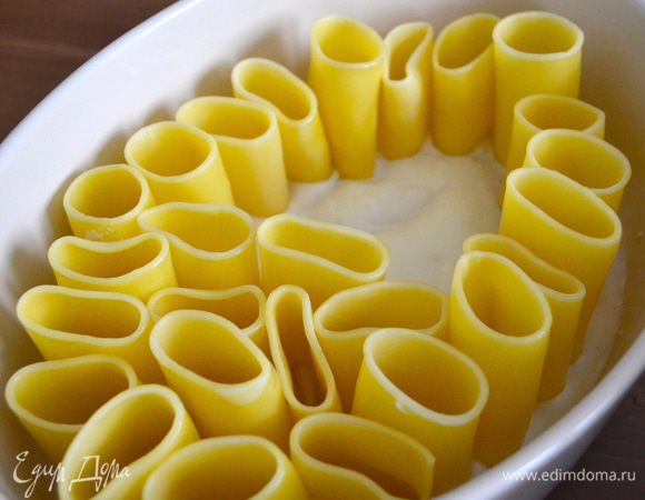 Теперь берем форму для запекания с высокими бортами (это важно!). Смазываем дно формы половиной соуса бешамель. И выкладываем в форму нашу пасту..."столбиками". Паста хорошо стоит и крепиться ко дну за счет соуса.