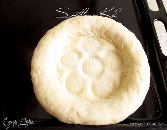 Затем надо серединку наколоть чекичем-специальным приспособлением для накалывания лепешек. У меня нет такого приспособления, я наколола вилкой, а затем выдавила цветочки донышком маленькой рюмки. Можно еще толстые  краешки тоже украсить, методом пощипывания.....