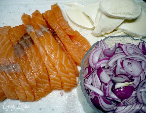 Шпинат размораживаем. Для начинки режем лук полукольцами и разделяем их на отдельные полосочки. Семгу режем вдоль на ломтики и разрезаем их затем поперек на две равные части. Моцареллу режем кружочками. Семгу сбрызгиваем лимоном, солим и перчим. 