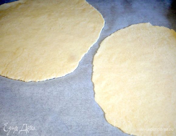 Духовку разогреваем до 250 градусов. Противень сразу ставим в духовку, чтобы он тоже нагревался. Тесто делим на 8 частей. Каждую часть раскатываем тонко, примерно в 2 мм толщиной. Выкладываем на пекарскую бумагу ( у меня получилось по 2 круга теста на один лист). 
