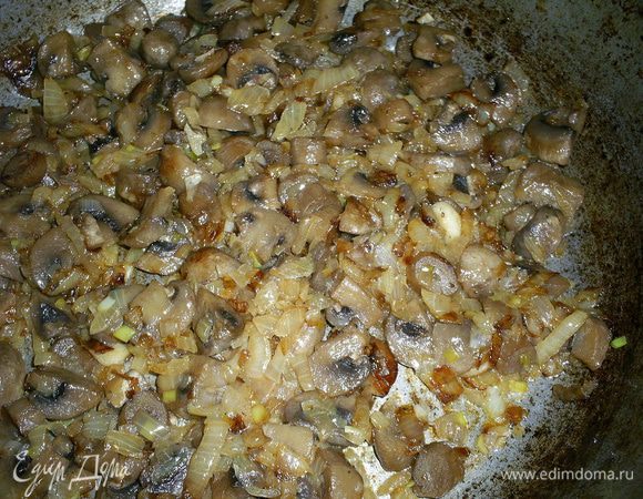 Приступаем к приготовлению крема. Лук мелко режем и обжариваем на сковороде до прозрачности, затем добавляем мелко порезанные шампиньоны и жарим до полного испарения жидкости. Солим, не забывая про соленый сыр, и еще немного обжариваем до золотистого цвета лука.