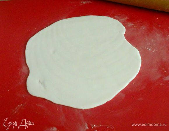 Сахарную мастику разделить на 4 кусочка, каждый раскатать на присыпанной сахарной пудрой поверхности.