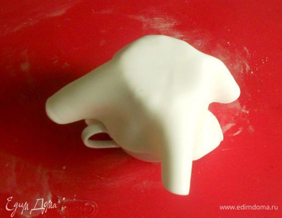 Перенести мастику на перевёрнутый вверх дном кекс, хорошо разгладить, обрезать ножницами излишки по краю кекса.