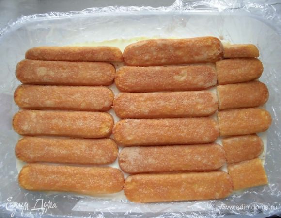 На крем снова выкладываем печенье. Тут его вмещается уже немного больше. Опять пропитываем молоком и выкладываем оставшийся крем.  