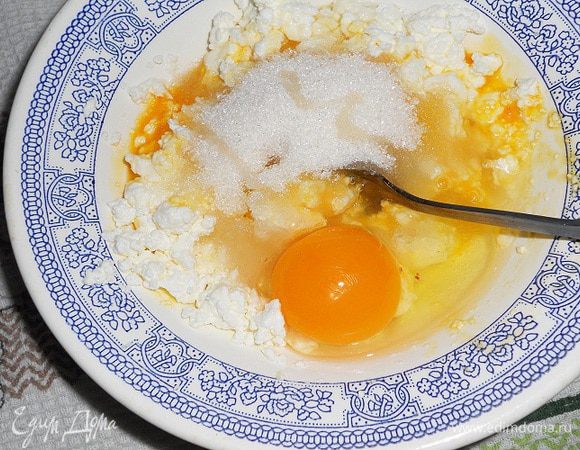 В творог добавить яйца, сахар, щепотку соли, ванилин - его можна заменить на пакетик ванильного сахара и перемешать.