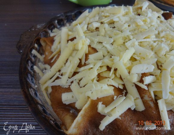 Накрыть верх выступающими краями блинов, полить заливкой, посыпать тертым сыром. Поставить в нагретую предварительно до 180 С духовку на 20-25 минут.