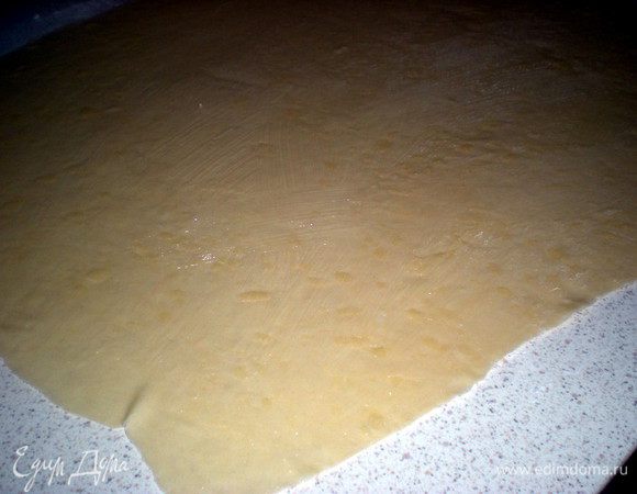 Присыпаем стол крахмалом. Оказывается, на нем действительно очень удобно раскатывать и говорят тогда тесто получается более нежное. Итак, раскатываем в максимально тонкий прямоугольник. Тесто получается эластичным и раскатывается очень хорошо,без разрывов.