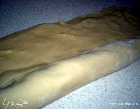 Верхний слой смазываем маслом и начиная с середины скручиваем в максимально тугой рулет.