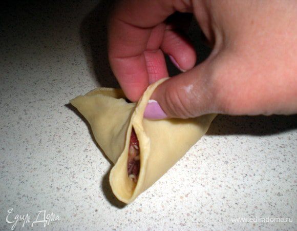 И собираем тесто в треугольник. Стараемся не испачкать края в мясе, иначе тесто будет сложно скрепить. Хорошенько защипываем края.