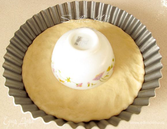 Выложить лепешку  в смазанную форму, где  будете выпекать пирог. Наметить центр круга и положить в круг перевернутое блюдце или пиалу. Там будет другая начинка.