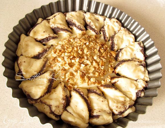 Освободить серединку от пиалы, предварительно вдавив ее в тесто хорошенько, чтобы оставить границу и начинки при выпечке не смешались. Дать пирогу немного подняться. Смазать его яйцом и серединку посыпать орехами. Выпекать при температуре 170 гр, минут 20, до зарумянивания, смотрите по вашей духовке.