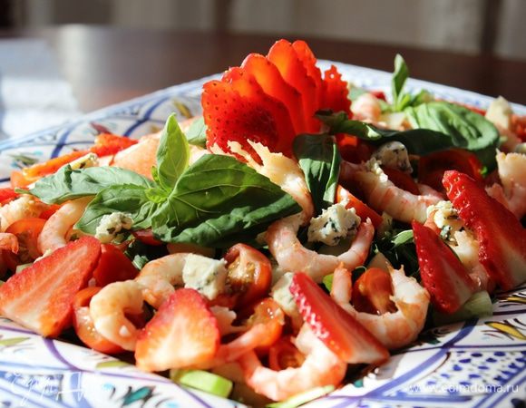 На дно большого блюда выложить рукколу, сверху груши, креветки, огурец, помидоры, голубой сыр и клубнику. Непосредственно перед подачей залить соусом (можно полить соусом только после того, как салат разложен по порционным тарелкам). В центре праздничного стола на общем большом блюде салат смотрится очень эффектно и привлекает к себе внимание. Угощайтесь!