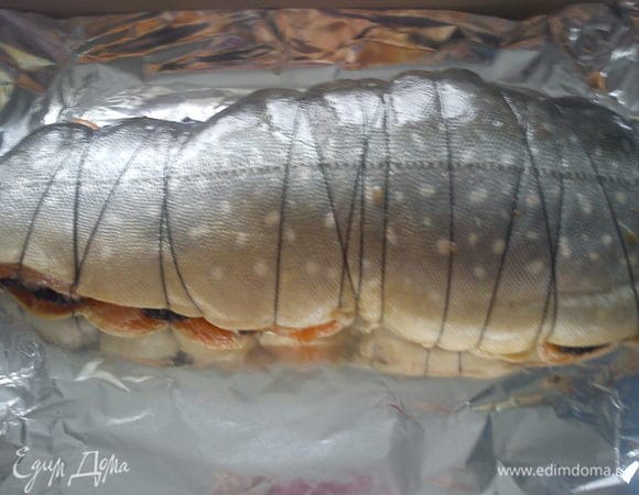 Перевязать рыбу пищевой ниткой и обмазать маслом от помидор. Выложить на лист для запекания. Запекать в духовке при 200 С 45 минут.