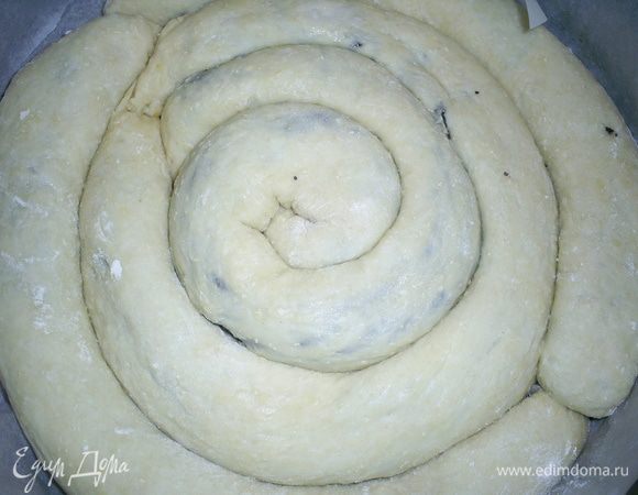 Наши длинные тонкие рулетики выкладываем в круглую форму диаметром 24-25см в виде спиральки. Дно формы я выстилаю бумагой для выпечки. Пирог рекомендуется оставить на расстойку. Я его просто поставила в холодную духовку. Перед выпечкой смазываем наш пирог желтком с водой. Выпекаем при температуре 220 градусов примерно 30-35 минут до зарумянивания.