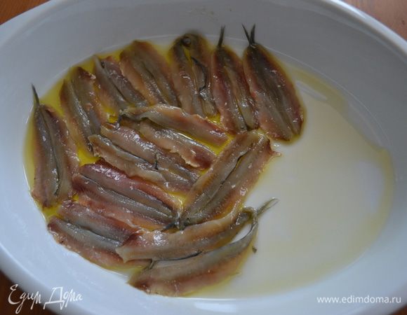 Взять форму для запекания и полить ее немного оливковым маслом. Начинаем выкладывать килек, первый слой - кожей (спинкой) вниз.  