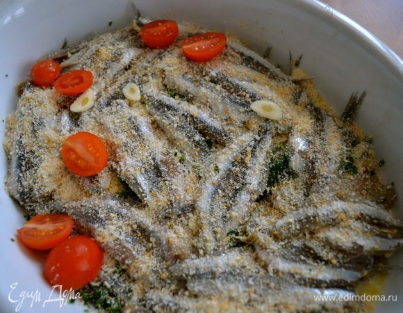 Поверх первого слоя выкладываем следующий слой рыбки на этот раз спинкой вверх. Так же посыпаем сухарями, чуть-чуть петрушкой, чеснок, соль, перец. И так далее... Последний верхний слой кильки должен быть тоже спинками вверх. Также присыпаем сверху сухарями, петрушкой и выкладываем разрезанные пополам помидорки-черри.  