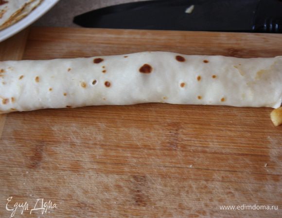 Сворачиваем в рулет и нарезаем на равные части (я резала на 4).Сверху из кондитерского шприца или корнета выдавливаем белковый крем (можно выложить ложкой)