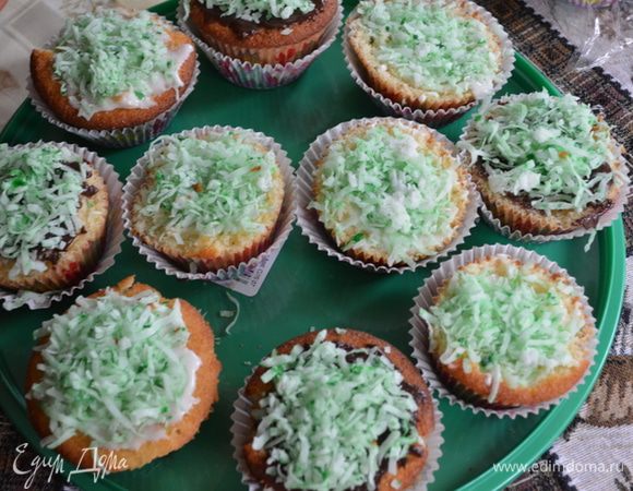 Нанесем на каждый капкейк сахарную глазурь купленную или домашнего приготовления,можно белую или шоколадную.Сверху выложим окрашенную зеленым цветом кокосовую стружку.