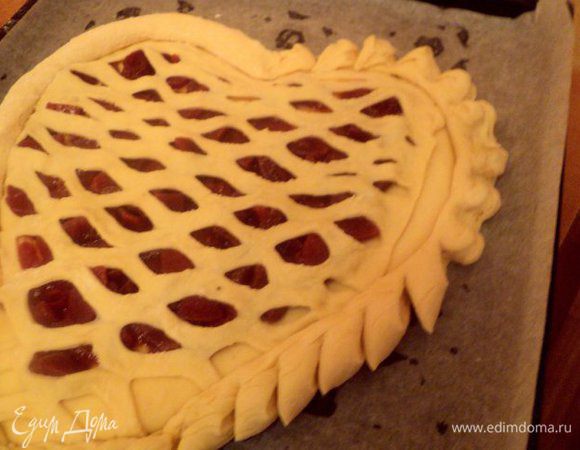 Оставшееся тесто раскатать в два валика и обернуть ими пирог. Ножницами надрезать тестяной валик и завернуть краешки.
Смазать пирог слегка взбитым яйцом.
