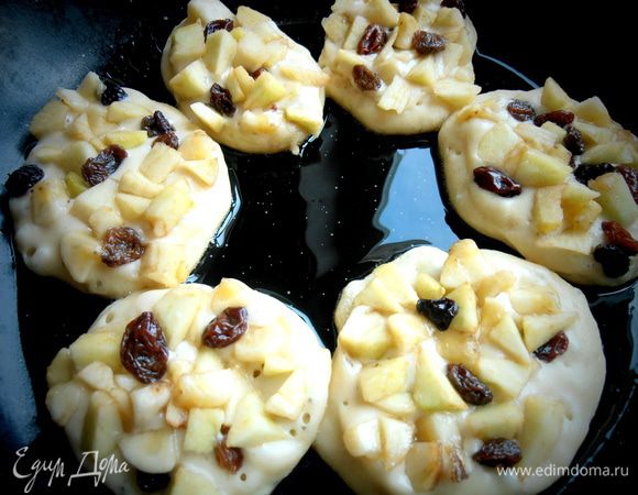 Столовой ложкой выкладываем тесто на разогретое масло и сверху распределяем фрукты.