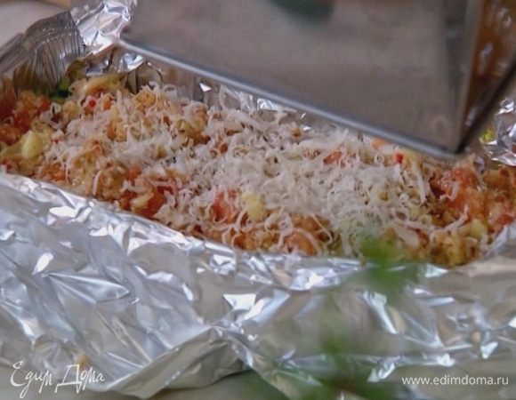 Небольшую форму для выпечки выстелить фольгой, плотно друг к другу выложить лодочки из цукини, наполнить их овощным фаршем, сбрызнуть оливковым маслом и посыпать оставшимся сыром.