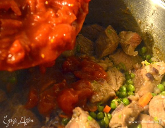 Как только мясо слегка зажариться добавить к нему помидоры в собственном соку. Как следует все перемешать.