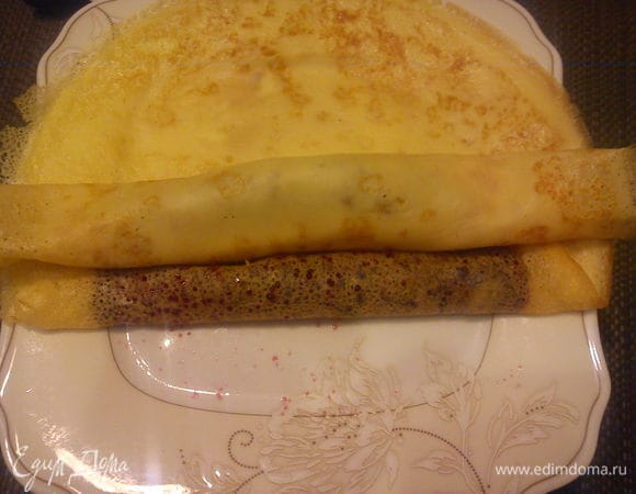 Положить сверху первый блинчик и свернуть теперь все в один рулетик